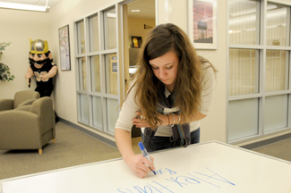 Philip Vukelich | Argonaut Campus Visit Office student worker Rylee Beasley changes the welcome whiteboard located in the University of Idaho Student Union Building Monday. The office helps recruit students to UI with campus tours and informational meetings for prospective students.